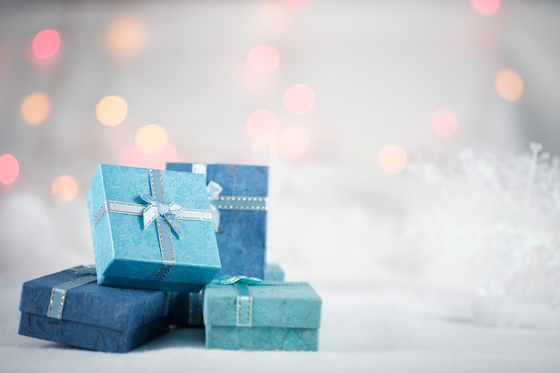 Blue gift boxes on the white fur on bokeh background. 