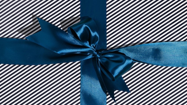 Photo blue gift ribbon and bow on black and white wrapping paper