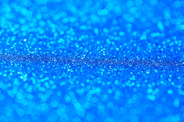 Blue glitter texture. New Year or christmas background for greeting card. Valentines Day celebration. Shiny sparkle design for festive decoration: wedding, holiday or anniversary party.