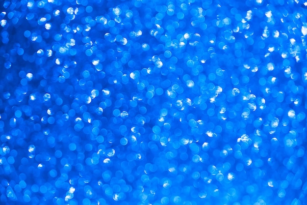 Blue glitter vintage lights background. blurred christmas abstract texture. defocused