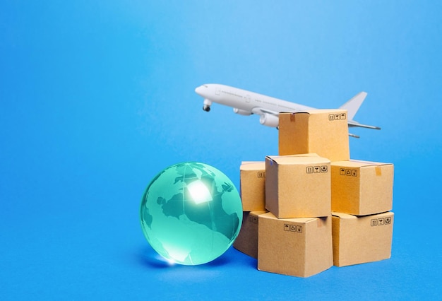 Photo blue globe cardboard boxes and freight airplane international world trade deliver goods shipping