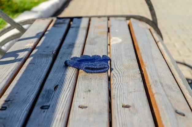 Photo a blue glove on a wooden bench is resting on a wooden table.