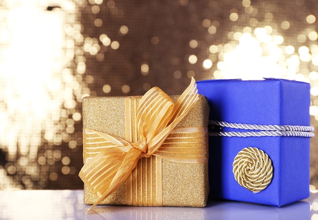 Blue and golden gift boxes on table on shiny surface