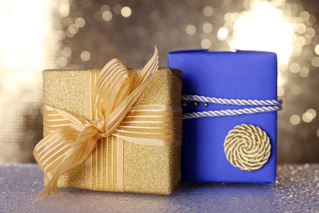 Blue and golden gift boxes on table on shiny surface