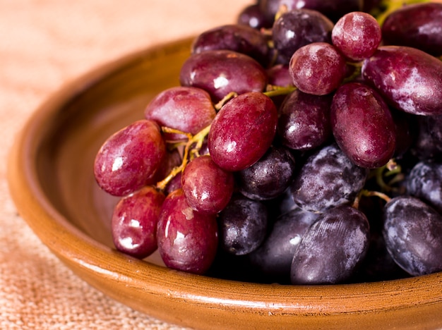 Blue grapes on a clay brown dish