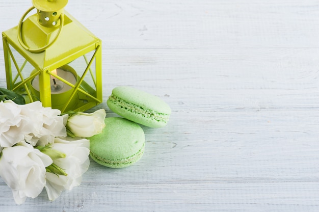 Blue green macaroons and lit candle in lantern