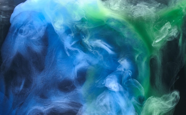 Blue green smoke on black ink background, colorful fog, abstract swirling ocean sea, acrylic paint pigment underwater