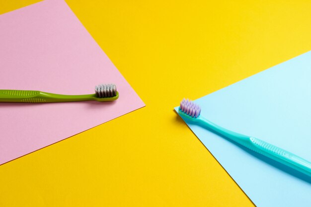 Blue and green toothbrushes on colored paper