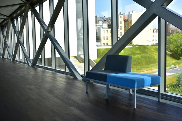 Blue and grey soft chairs in a long corridor dark wooden floor Panoramic windows Poznan Poland