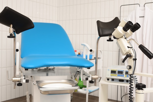 Blue gynecological chair and colposcope in a modern clinic