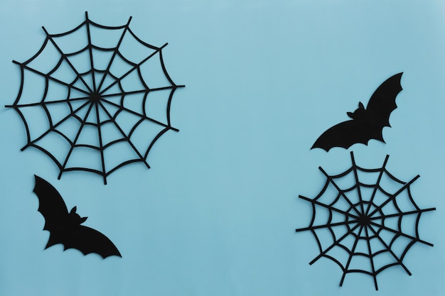 Photo blue halloween background with black paper bats and web copy space