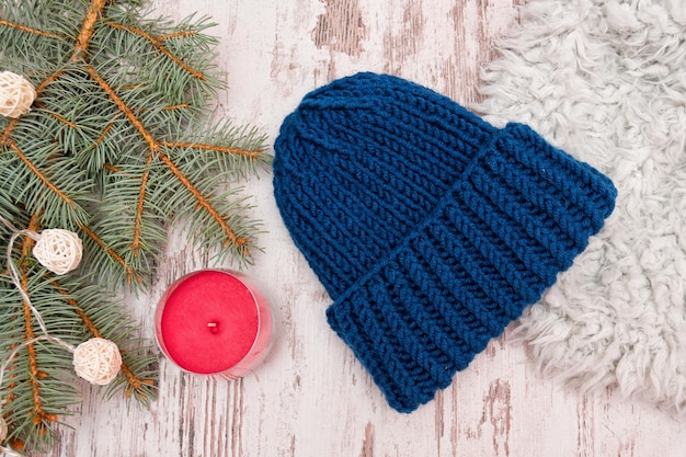 Синяя шляпа Еловая ветка гирлянда и свеча Деревянный фон Новогодняя концепция