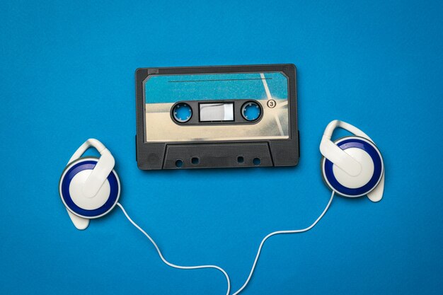 Blue headphones and a blue tape recorder on a blue background.