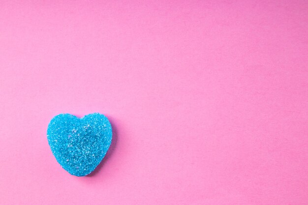 Blue heart shaped gummi candy on pink