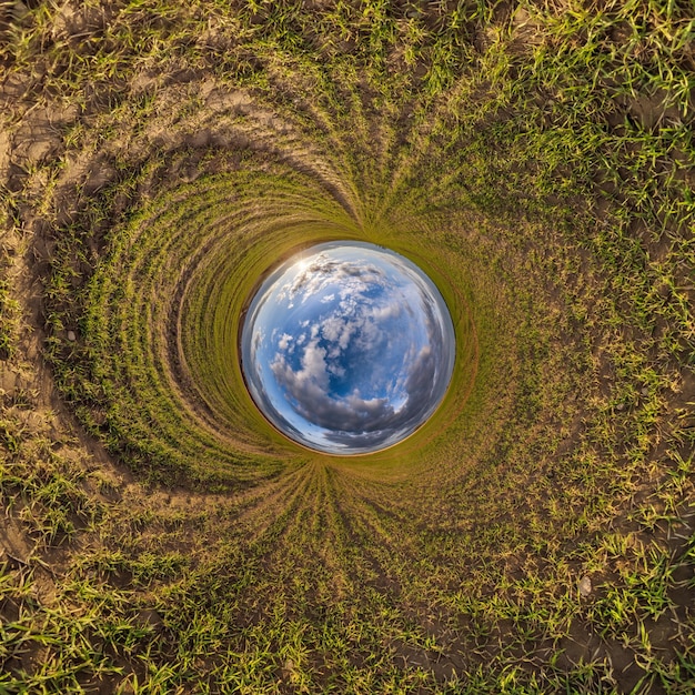 Foto buco blu sfera piccolo pianeta all'interno di erba verde sfondo cornice rotonda