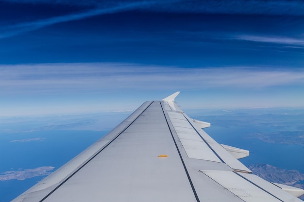 翼が見える飛行機からの空中ショットの柔らかい雲と青い地平線