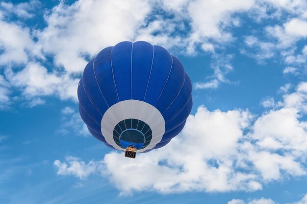 Foto volo in mongolfiera blu sopra il cielo blu con nuvole bianche