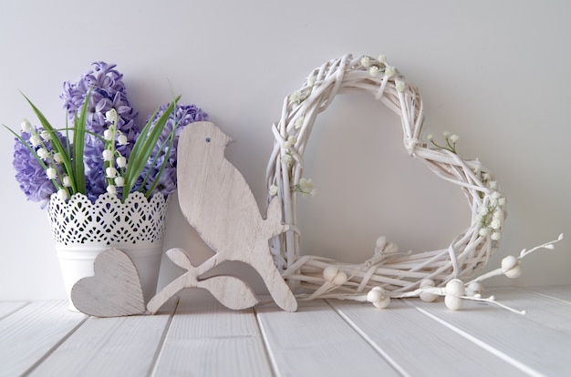 Foto fiori blu del giacinto e del mughetto, cuore di legno, uccello e un cuore bianco dell'acacia