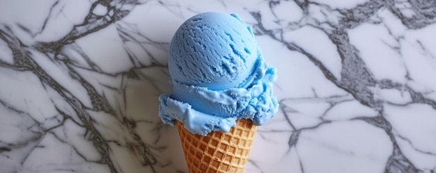 大理石の背景のワッフルコーンに青いアイスクリームスコープ