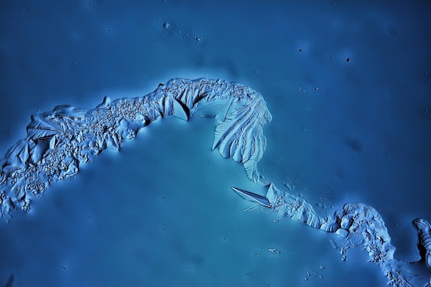 blue ice glass background, abstract texture of the surface of the ice on the glass, frozen seasonal water