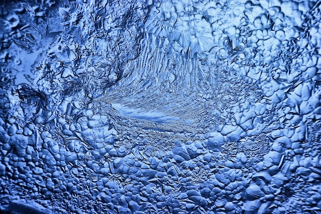 blue ice glass background, abstract texture of the surface of the ice on the glass, frozen seasonal water