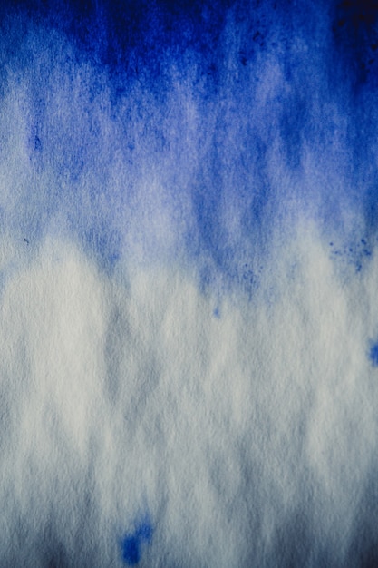 Photo blue ink stain on a sheet of white paper macro. abstract background. spreads ink stains with streaks on a white background. absorb close-up