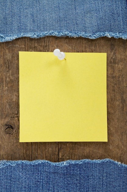 Blue jean and note paper on wood texture