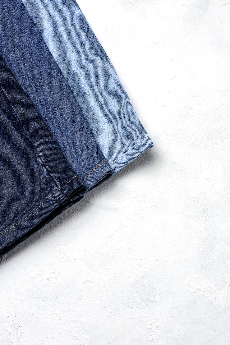 Foto blue jeans broek kleren stapel achtergrond. detail van mooie spijkerbroek