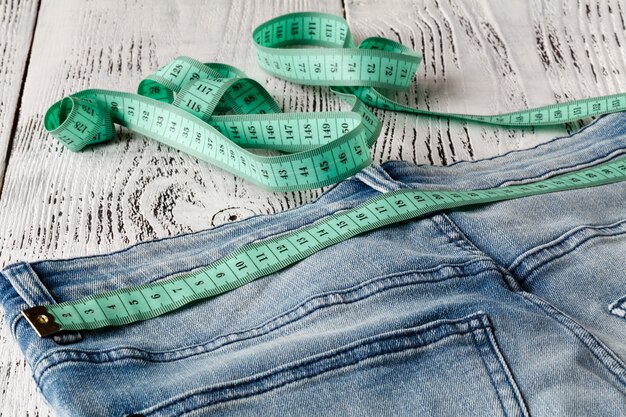 Blue jeans and measuring tape in waistband and in body