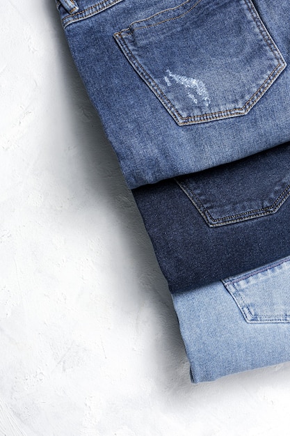 Fondo del mucchio dei vestiti dei pantaloni delle blue jeans. dettaglio di bei blue jeans