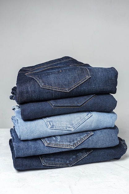 Photo blue jeans pants clothes pile background. detail of nice blue jeans