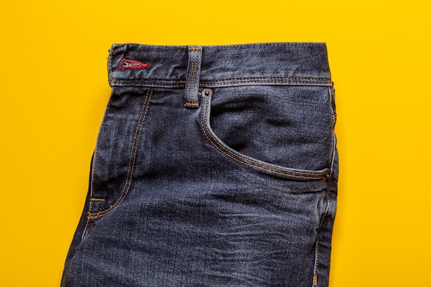 Blue jeans texture on a yellow background