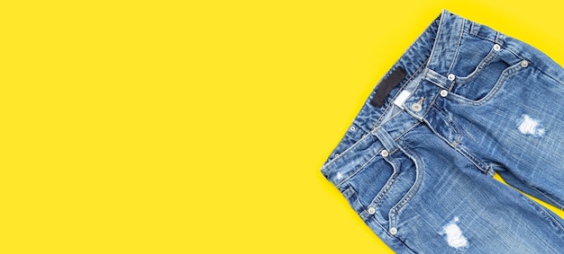 Blue jeans on yellow background.