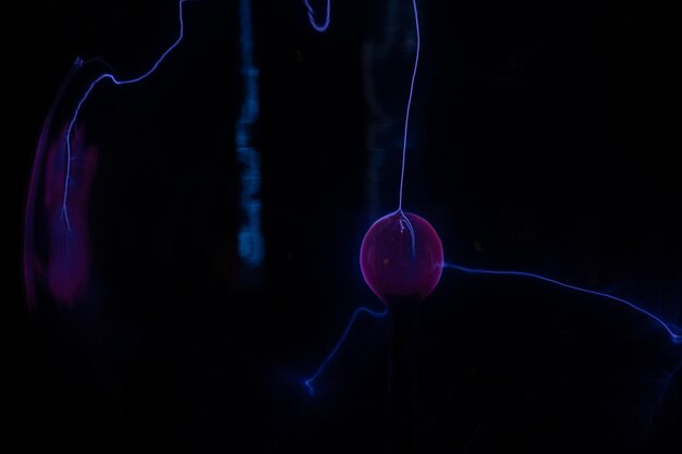 A blue jellyfish is shown in the dark.