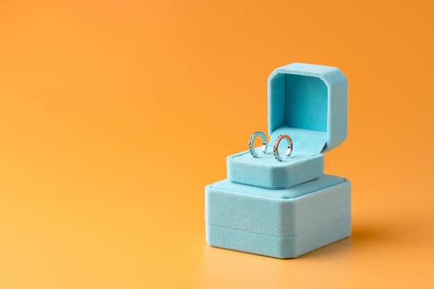 Photo blue jewelry box on yellow background close up