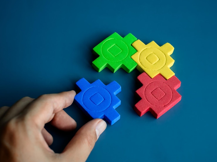 Photo blue jigsaw piece in hand wait to fulfill to complete with the group red yellow and green puzzle blocks on blue background minimal style business partnership teamwork and solution concepts