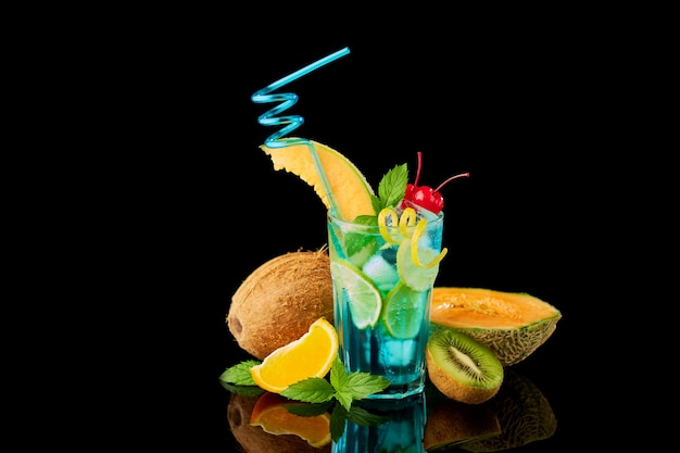 Blue lagoon cocktail with a slice of melon and cherry isolated on white