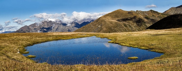 秋の晴れた日の山の尾根の背景に青い湖