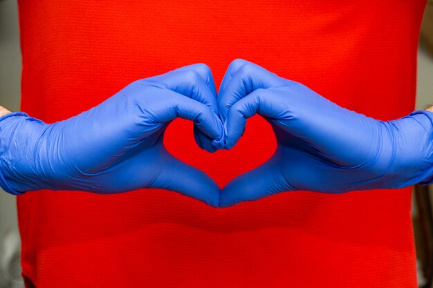 Foto guanti in lattice blu per protezione medica a forma di cuore simbolo, supporto per medici e infermieri, covid-19, coronavirus.