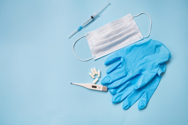 Blue latex gloves with pills and medical mask