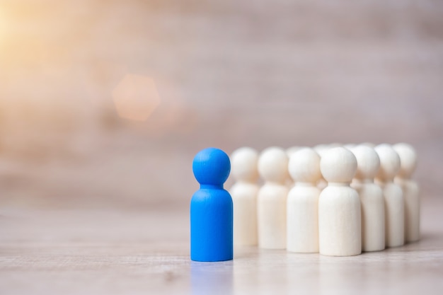 Blue leader businessman with crowd of wooden men. leadership, business, team, teamwork and Human resource management 