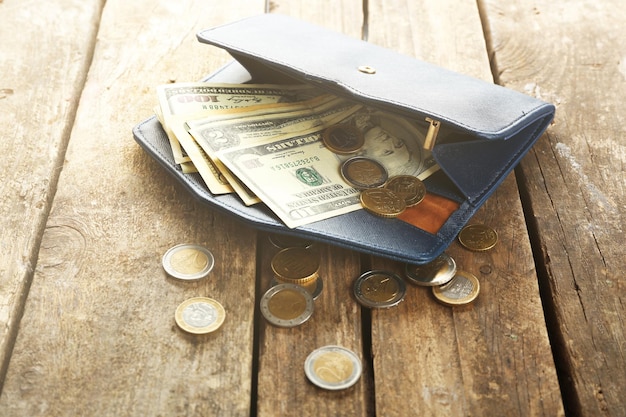 Blue leather wallet with money on wooden table