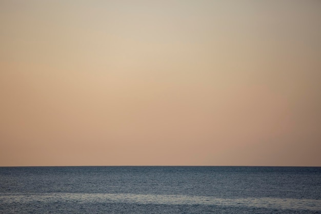 穏やかな海水と黄色い夕空の青いライン