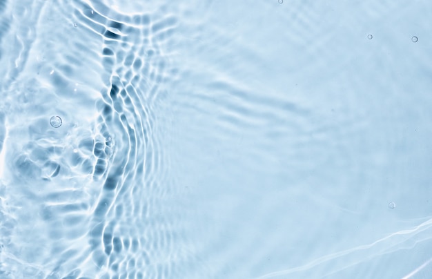 Фото Синяя жидкость цветная прозрачная текстура поверхности воды с брызгами пузырей