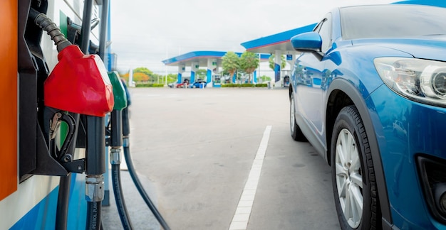 Blue luxury SUV car fueling at gas station Refuel fill up with petrol gasoline Petrol pump filling