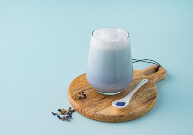 blue matcha latte and spoon on a wooden board