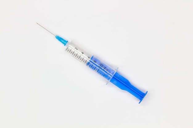 Blue medical disposable syringe for injection on a white background medical instrument