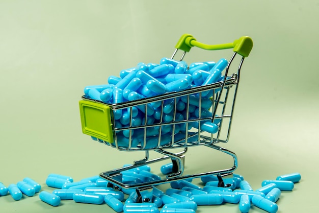 blue medicine capsule in miniature shopping cart