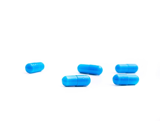 Photo blue medicine or food supplement capsules isolated on white