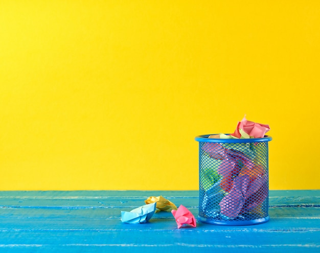 Blue metal bucket filled with crumpled  paper